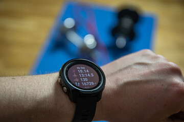 Fototapeta premium Workout at home. Close up shot of smartwatch which shows productive training. Sport watch shows info about workouts.