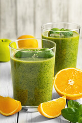 Healthy green smoothie with spinach in glass jars.