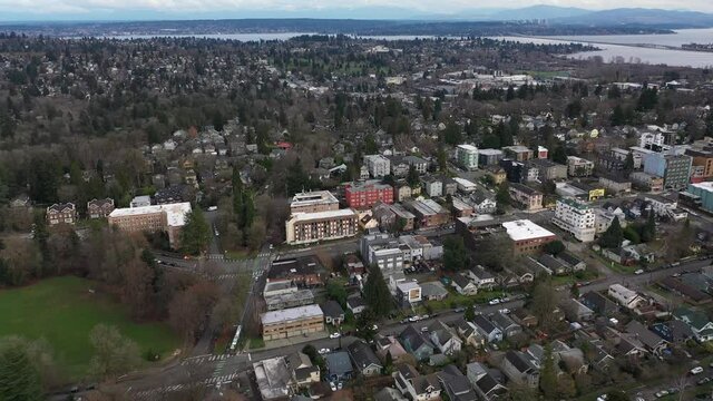 Cinematic aerial drone dolly shot of Cowen Park, Seattle Children's Hospital, Roosevelt, Ravenna, Laurelhurst, University District, Lake Washington and downtown Seattle in the distance