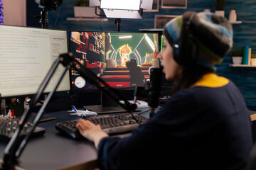 Pro streamer use headphones and looking into powerful monitor with gaming chat open. Online...