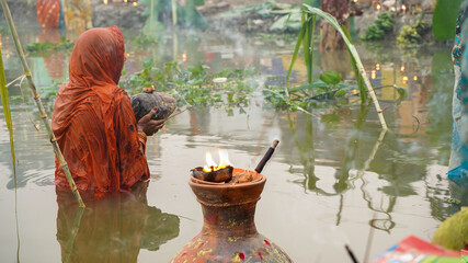Woman in middle of the lake celebrating chhath festival          