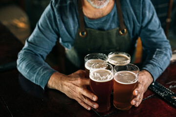 middle aged man bartender serving beer in beer pub