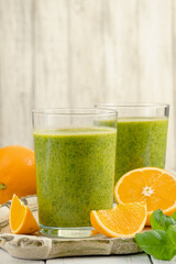 Healthy green smoothie with spinach in glass jars.