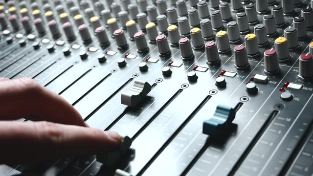 Close up footage of sound engineer working at audio mixer
