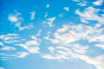 Natural sunny blue sky background with beautiful puffy white cumulus clouds and fluffy cirrus...