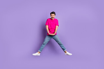 Fototapeta na wymiar Full size photo of young happy excited cheerful crazy man jumping screaming isolated on violet color background