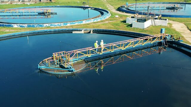 Top view of a wastewater reservoir getting observed by specialists