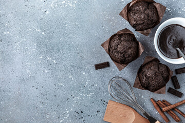 Homemade chocolate muffins with set of kitchen utensils on on gray blue background. Copy space.