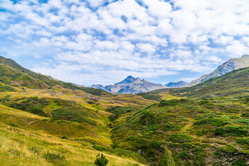 Picturesque view of Pyrenees landscape with green meadows and mountains in daytime. Summer vacation trip in the mountain, in the Val D'aran, Aran Valley, Pyrenees, Catalonia, Spain.