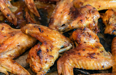Close up of fried homemade chicken wings with garlic and caraway seeds on it.