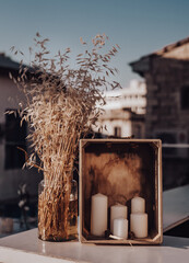 Candles in a box next to a vase for decoration at a dinner
