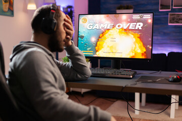 Professional gamer man playing space shooter video game on computer for championship. Cyber...