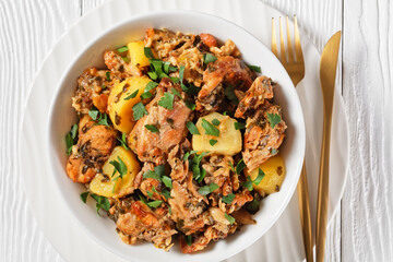 braised Rabbit with potatoes in a white bowl