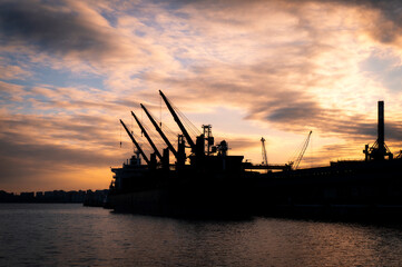 Obraz premium silhouette of a ship standing in the port against the background of the evening sky