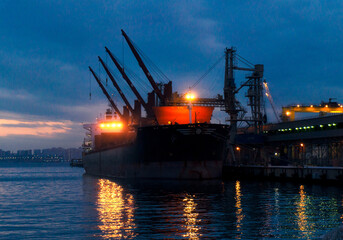 a large ship is in the port in the evening for loading
