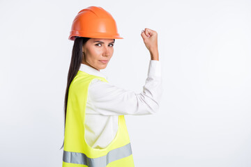 Photo of strong serious lady raise arm show biceps look camera wear helmet shirt vest isolated...