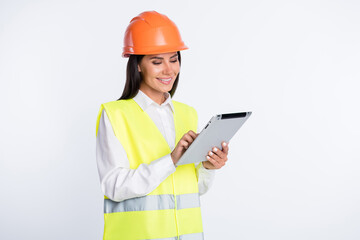 Photo of cheerful worker lady hold e-reader look screen wear helmet shirt vest isolated white color background
