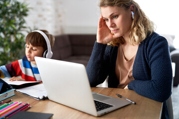 Fototapeta na wymiar Frustrated mother during home office with her son at home