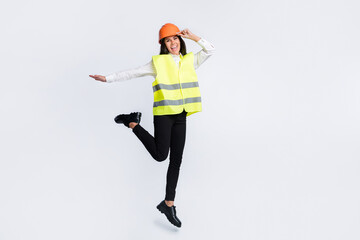 Photo of excited crazy builder lady girlish jump wear helmet shirt vest trousers shoes isolated...