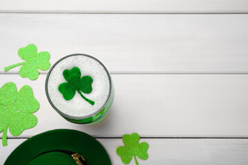 Beer and St Patrick's Day decor on white wooden table, flat lay. Space for text