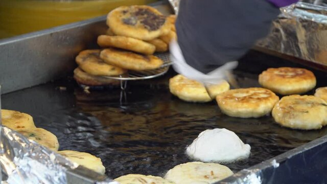 Hands of a man Cooking Hotteok - Korean Pancake And Popular Street Food In South Korea. close up