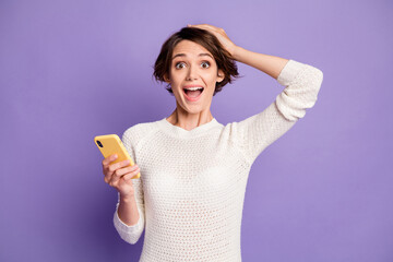 Obraz premium Photo portrait of girl with bob hair amazed touching head browsing internet isolated on pastel purple color background