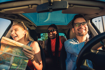 Three best friends enjoying traveling at vacation in the car.