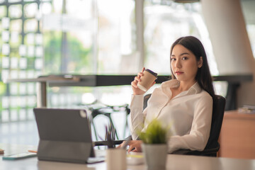 Obraz premium Businesswoman having tea or coffee in home office.