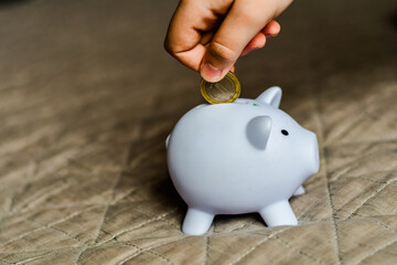 Little boy putting coin into a piggy bank.Donation,saving,charity ,family finance plan concept.Superannuation