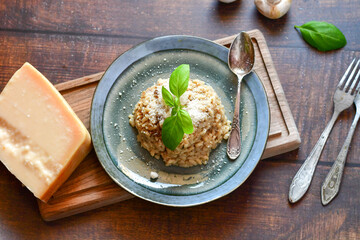Italian  home made creamy   mushroom risotto with parmesan cheese and fresh basil on rustic background