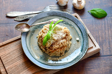 Italian mushroom risotto with parmesan cheese and fresh  parsley on rustic background