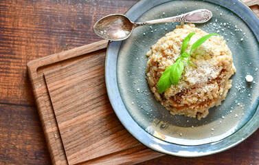 Italian mushroom risotto with parmesan cheese and fresh  parsley on rustic background