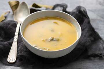 vegetable soup with spinach in the bowl on ceramic background