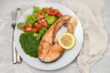 fried salmon with spinach and salad on white plate