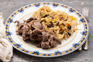 noodles with vegetables and meat on the dish