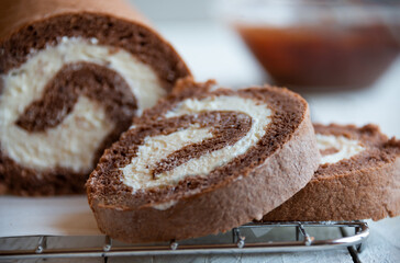 Fototapeta na wymiar Sweet roll with wiped cream, delicious chocolate cake