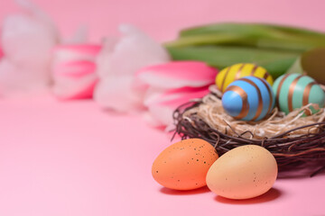 Easter eggs in a nest on a background of tulips. Holiday concept. Easter card.Copy space for text