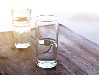 two Glasses clean of water on a wooden table.