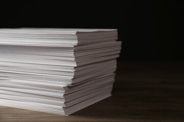 Stack of paper sheets on wooden table, closeup. Space for text