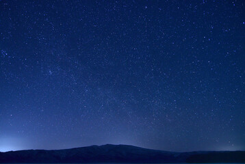 Fototapeta na wymiar 山のシルエットと満天の星空。