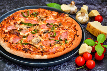 Tasty hot italian carbonara pizza with ham, bechamel sauce,mushroom,tomatoes  and cheese. Pizzeria menu. Concept poster for Restaurants or pizzerias. Top view,dark  background