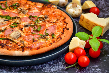 Tasty hot italian carbonara pizza with ham, bechamel sauce,mushroom,tomatoes  and cheese. Pizzeria menu. Concept poster for Restaurants or pizzerias. Top view,dark  background