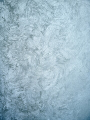 Decorative plaster in interior design. Surface of wall decoration texture stucco with imitation of stone travertine in pastel dull blue color.