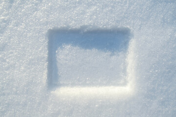 Naklejka na ściany i meble Imprint of a rectangular frame in the snow, on a sunny winter day. Copy space. 