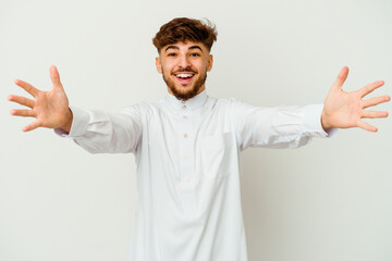 Young Moroccan man wearing a typical arab clothes isolated on white background feels confident giving a hug to the camera.