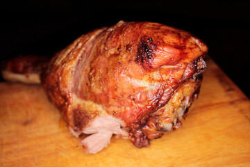 Appetizing roast turkey shank on a plate close up