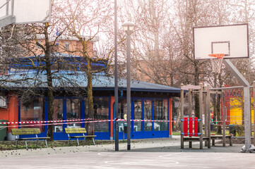 Closed public playground during quarantine and pandemic, red and white tape restricts the passage