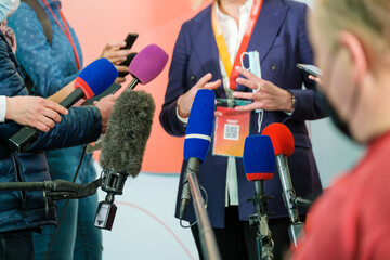 Crop businesswoman speaking with journalists
