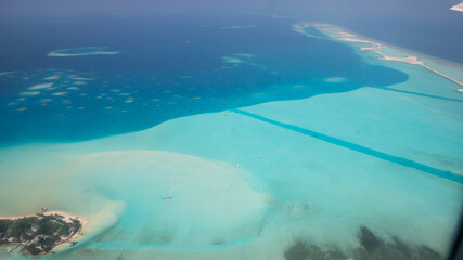 a background of natural small beautiful islands in ocean on a view with sky and clouds from the window of an airplane, beard eyes drone