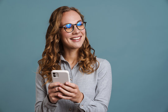 Cheerful young girl usig mobile phone isolated